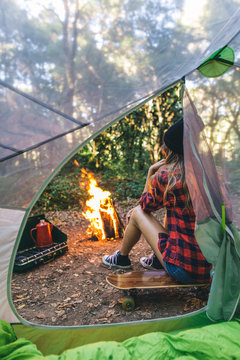 Woman sitting next to tent