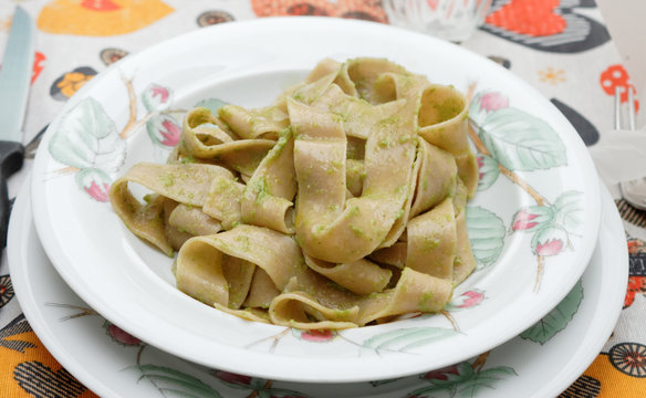 Pappardelle pasta with pesto on a white plate