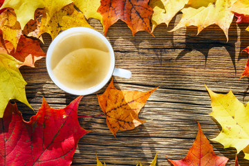 coffee cup on the wooden background with autumn leaves