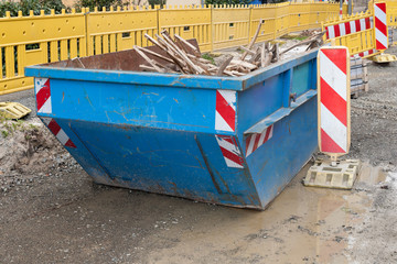 Fototapeta na wymiar Ein blauer Container mit Holzabfall auf einer Baustelle