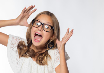 Emotional blonde girl in a white dress with glasses on a white background