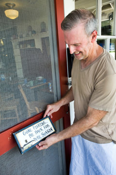 Cafe owner putting up signage on front door