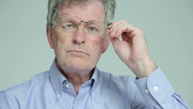 Depressed, sad man takes off glasses and sighs
