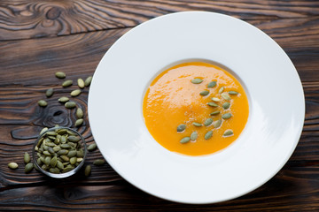 Glass plate with pumpkin cream-soup, studio shot