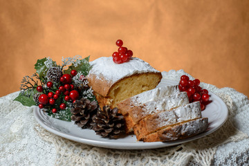 Traditional fruitcake for Christmas decorated with powdered sugar and fresh berry