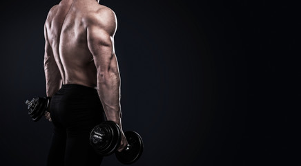 Obraz na płótnie Canvas Bodybuilder doing exercises with dumbbells