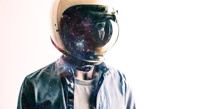Futuristic portrait of a young man in a casual shirt and a white helmet with starry sky projected on the shield isolated on white Double exposure.