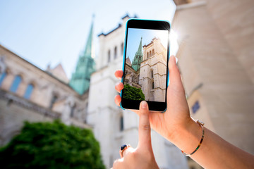 Photographing with phone famous Saint Pierre church in the old town of Geneva city in Switzerland