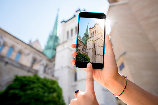 Photographing with phone famous Saint Pierre church in the old town of Geneva city in Switzerland