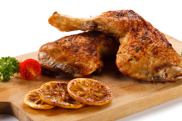 Roast chicken legs on cutting board 