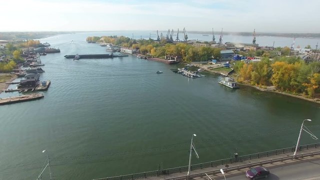 Flying over the bridge at Samara river with river cranes at background . Car traffic at bridge.  Drone moving forward. 4K Aerial stock footage clip.
