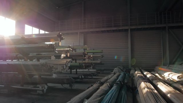 Steel Pipes bunch on the rack in warehouse. Modern stock on sunset, flares