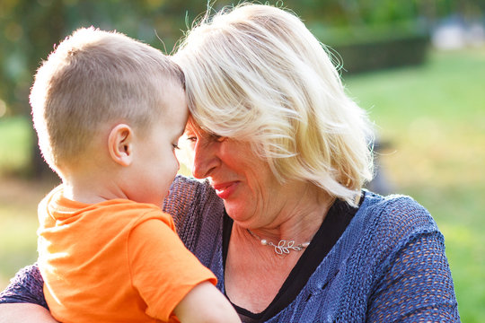 Portrait of happy grandmother with grandson embracing outdoor