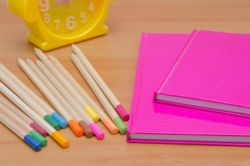 Comodino con matite colorate agende e sveglia