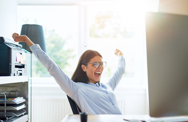Joyous woman in small office with extended arms