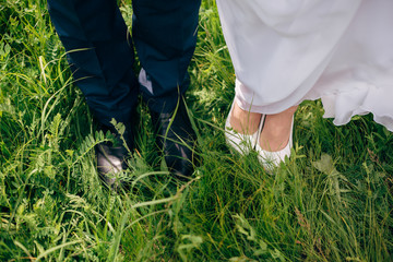 bride and groom standing on bridge at sunny day