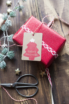 Christmas decoration and wrapped present on wood
