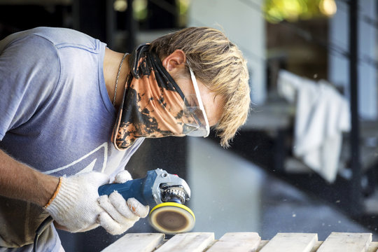 Man sanding wood with a random orbital sander