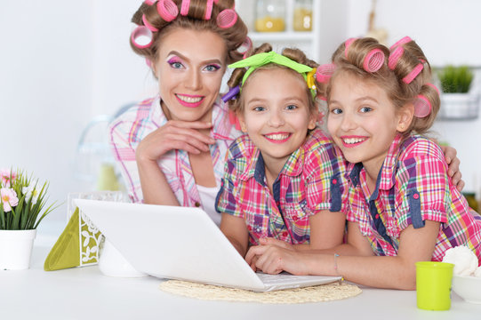 girls and mother  in hair curlers  with laptop