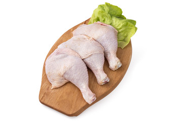 Fresh raw chicken legs arrangement on kitchen cutting board with lettuce - 123236628