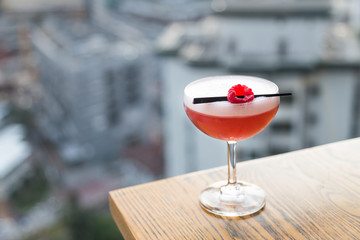 Red cocktail with cherry on table top