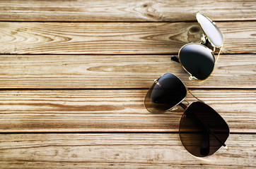 two unisex sunglasses on a wooden background top view