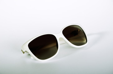 one white female sunglasses on a light gray background
