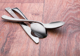flatware set of spoons and knife on wooden surface