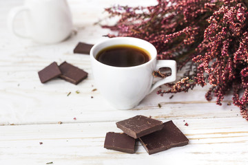 Cup of coffee, dark chocolate and heather flowers