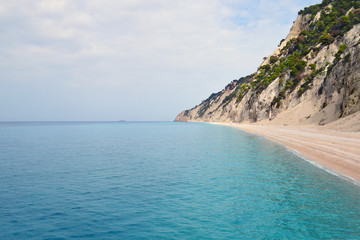 Obraz premium Steep rocky hills falling to secluded beach and calm turquoise sea