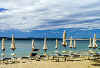 Empty sea beach with closed sun-umbrellas, Croatia, stormy weath