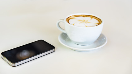 coffee and smartphone on wooden table and copy space, soft focus