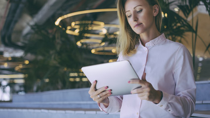 A girl in a light pink shirt surf the Internet on a digital tablet.Business woman checks email on a...