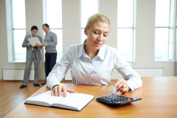 Female accountant working in office with business people in the background