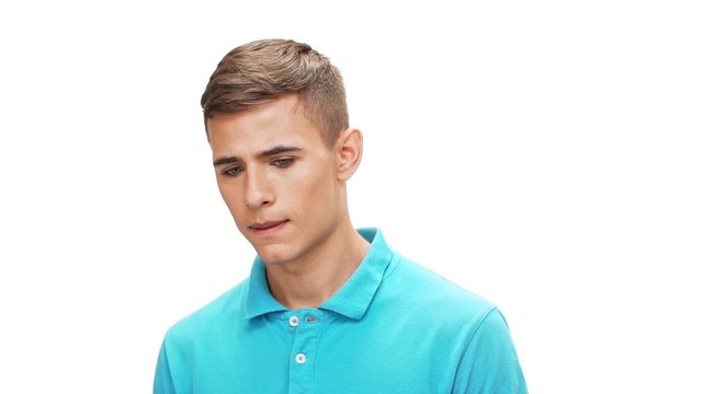 Upset young man looking at camera over white background Slow motion