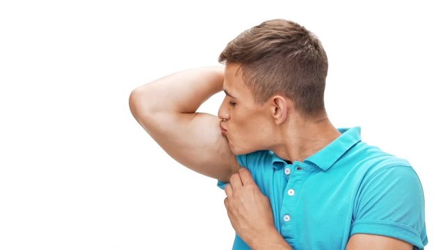 Man showing muscles smiling kissing biceps over white background Slow motion