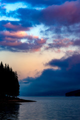 Morning colorful clouds above the calm waters of the lake
Dramatic colorful clouds over the waters of lake Dospat in Bulgaria shortly before the sunrise.