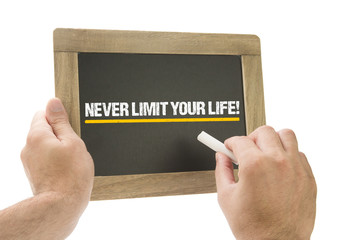 Never limit your life! Hand writing on chalkboard