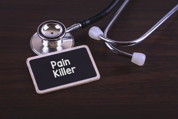 Medical Concept- Pain Killer words written on label tag with Stethoscope