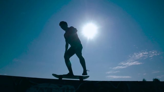 Artistic skater silhouette at sunset. Super slow motion. HD.
