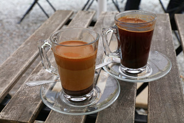 Two Turkish coffee glass cups, black and with milk