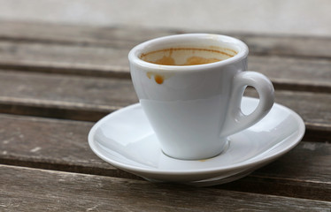 Espresso coffee in white cup close up on table
