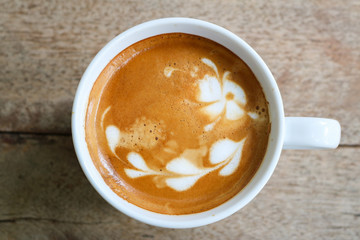 Top view coffee cup latte art on wood table.