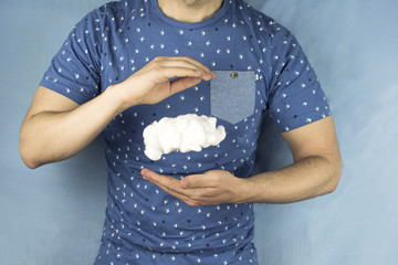 Chico con camiseta de pájaros hace levitar una nube entre sus manos sin llegar a tocarla. Parece un truco de magia.