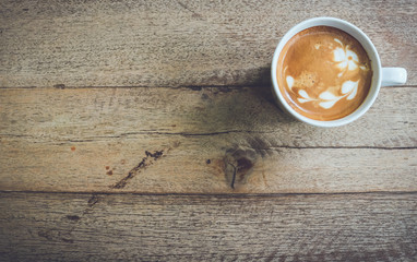 Top view coffee cup latte art on wood table vintage tone.