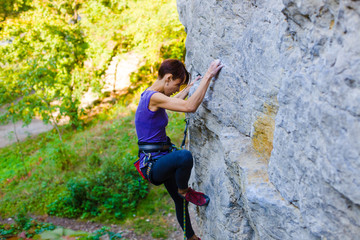 The girl climbs the rock.