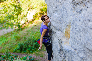 The girl climbs the rock.