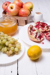 Pieces ripe pomegranate, honey, grapes and apple