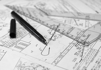 Pen and setsquare lying on a flight paperwork