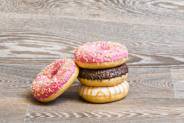 Hand decorated donuts, isolated on a wooden background